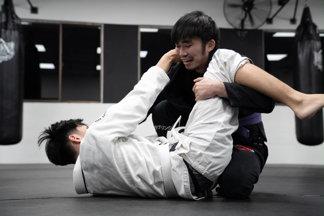 Two Brazilian Jiujitsu students grappling in gi on the mats
