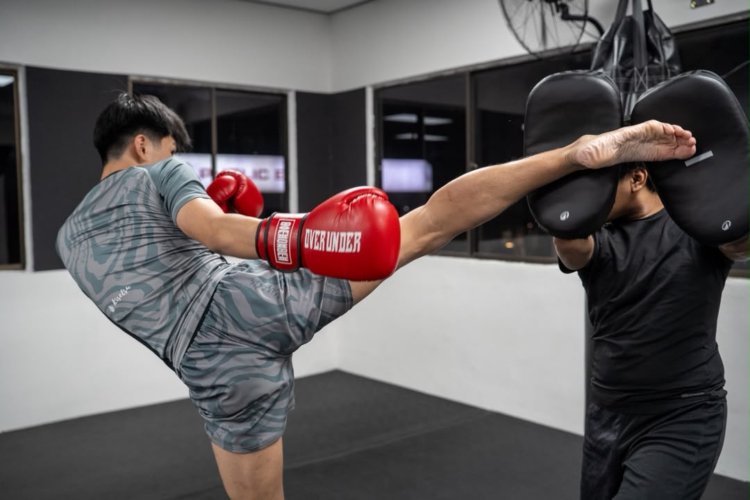 Muay Thai student throwing a kick during pad work